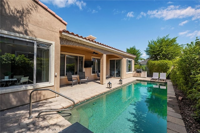 view of swimming pool with ceiling fan and a patio