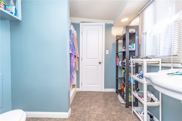 interior space with vaulted ceiling and dark tile patterned flooring