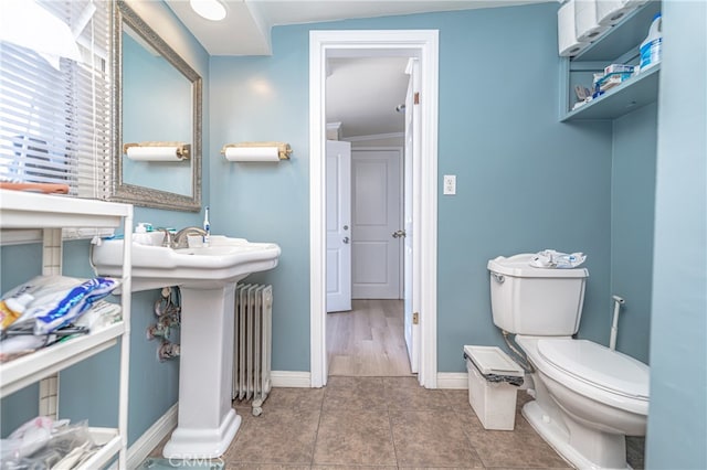 bathroom with tile patterned flooring, radiator, and toilet