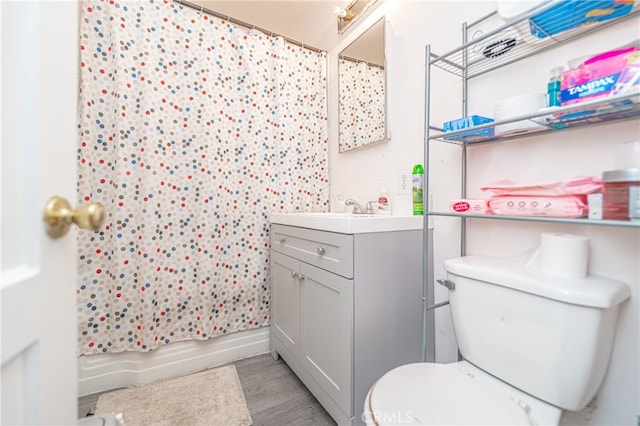 full bathroom featuring vanity, hardwood / wood-style floors, toilet, and shower / bathtub combination with curtain