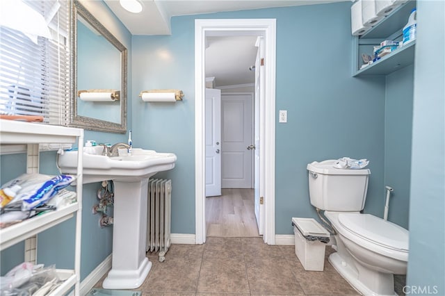 bathroom featuring toilet, radiator heating unit, and tile patterned floors