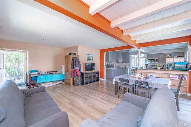 living room with light hardwood / wood-style flooring and beamed ceiling