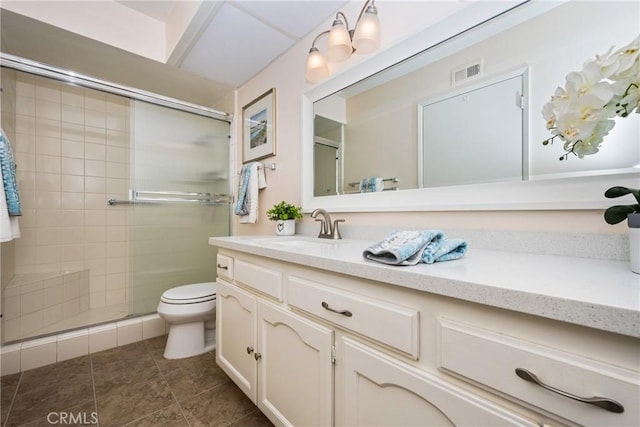 bathroom with toilet, vanity, visible vents, a shower stall, and tile patterned floors