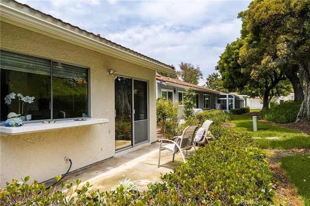 exterior space with a patio and stucco siding