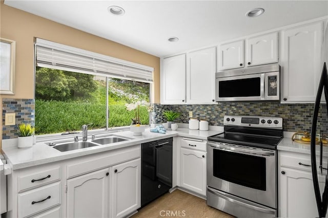 kitchen with a healthy amount of sunlight, white cabinets, stainless steel appliances, and a sink