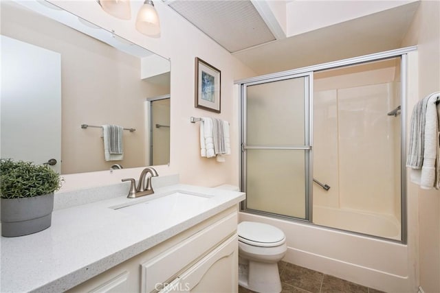 full bathroom with enclosed tub / shower combo, vanity, toilet, and tile patterned floors