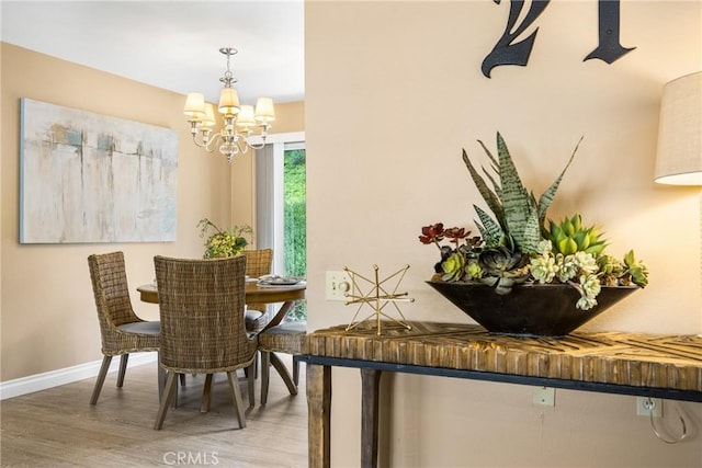 dining room with an inviting chandelier, baseboards, and wood finished floors