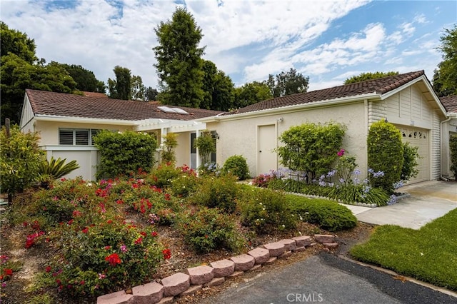 view of front of property with a tile roof, an attached garage, and stucco siding