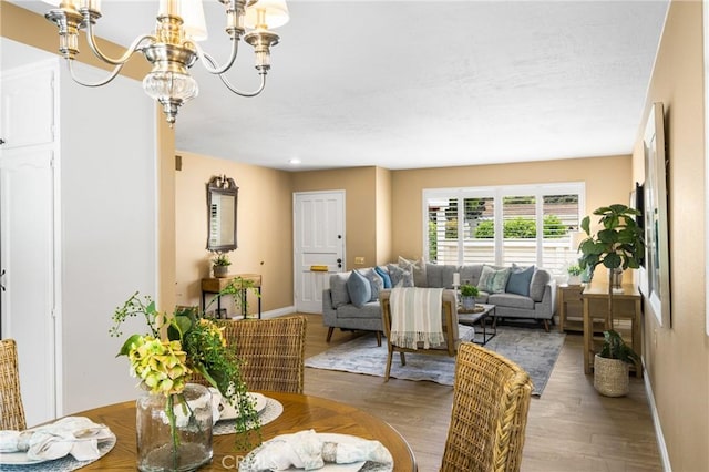 dining room with baseboards, a chandelier, and wood finished floors