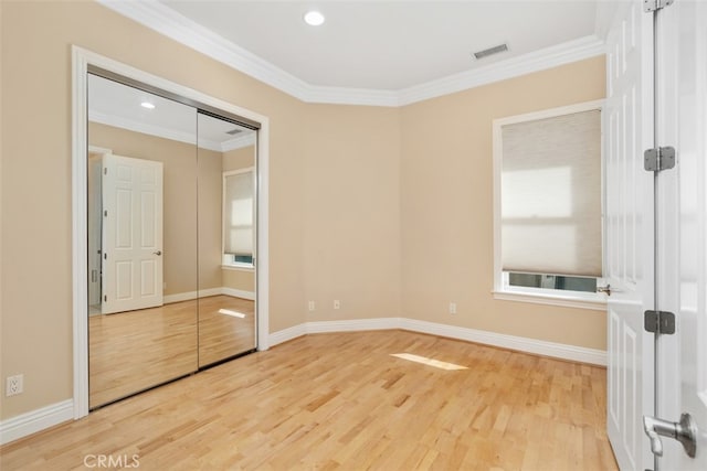 unfurnished bedroom with a closet, ornamental molding, and hardwood / wood-style floors