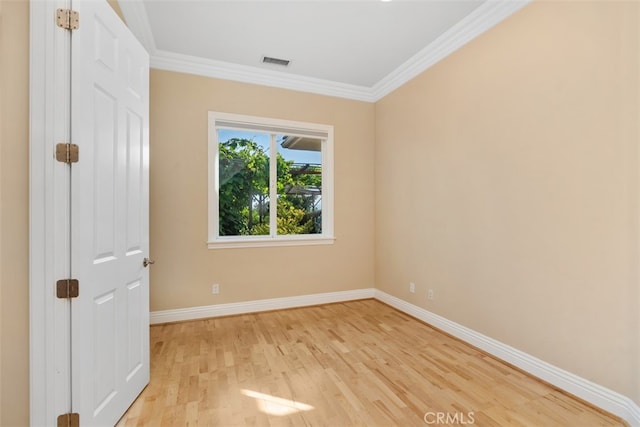 spare room featuring crown molding and light wood-type flooring