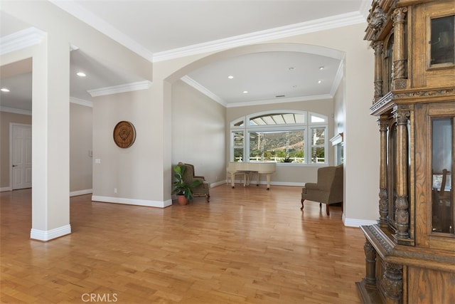 entryway with ornamental molding and light wood-type flooring