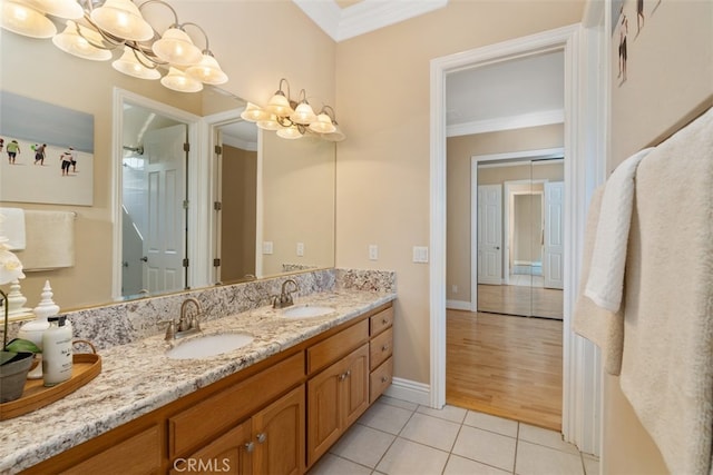 bathroom featuring vanity, ornamental molding, a chandelier, and hardwood / wood-style floors