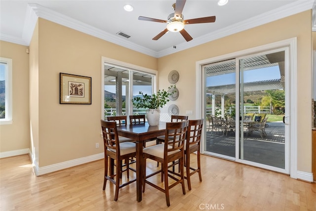 dining room with light hardwood / wood-style flooring, ornamental molding, and ceiling fan