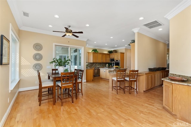 dining room with crown molding, light hardwood / wood-style flooring, and ceiling fan