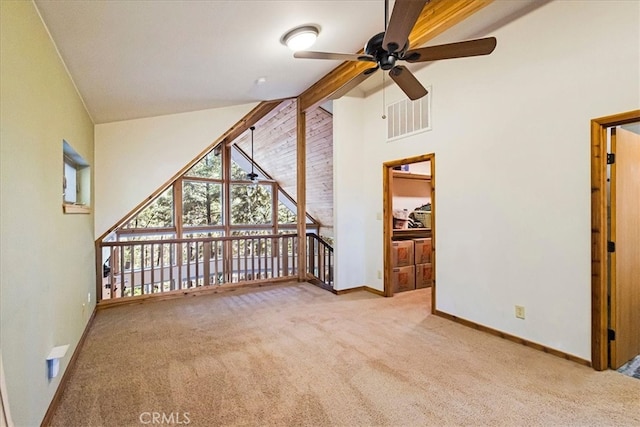interior space featuring light carpet, beam ceiling, high vaulted ceiling, and ceiling fan