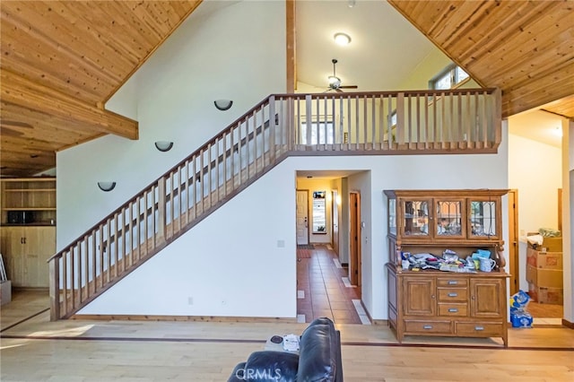 stairs featuring wood ceiling, high vaulted ceiling, wood-type flooring, and ceiling fan