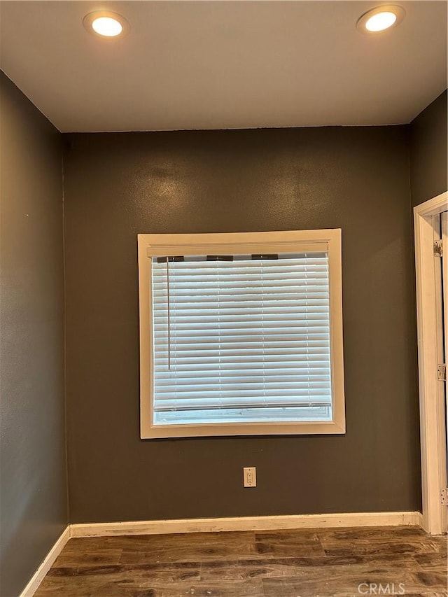 unfurnished room featuring a healthy amount of sunlight and dark hardwood / wood-style floors