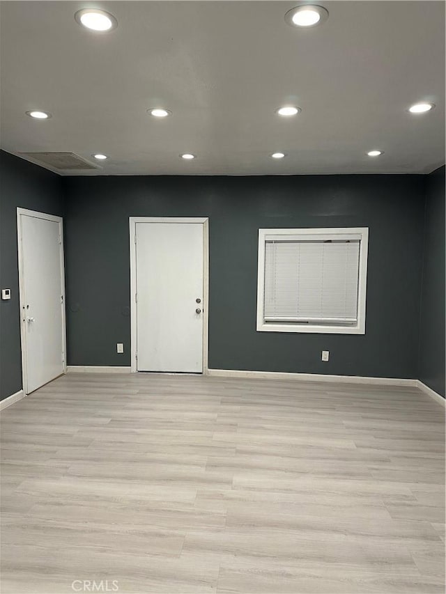 empty room with light wood finished floors, baseboards, and recessed lighting