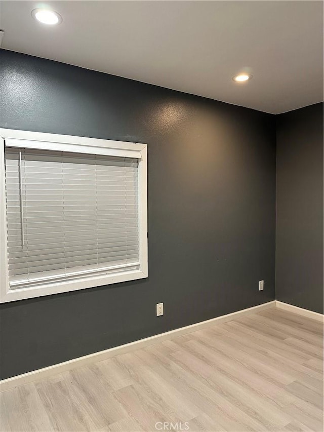 empty room featuring wood finished floors, baseboards, and recessed lighting