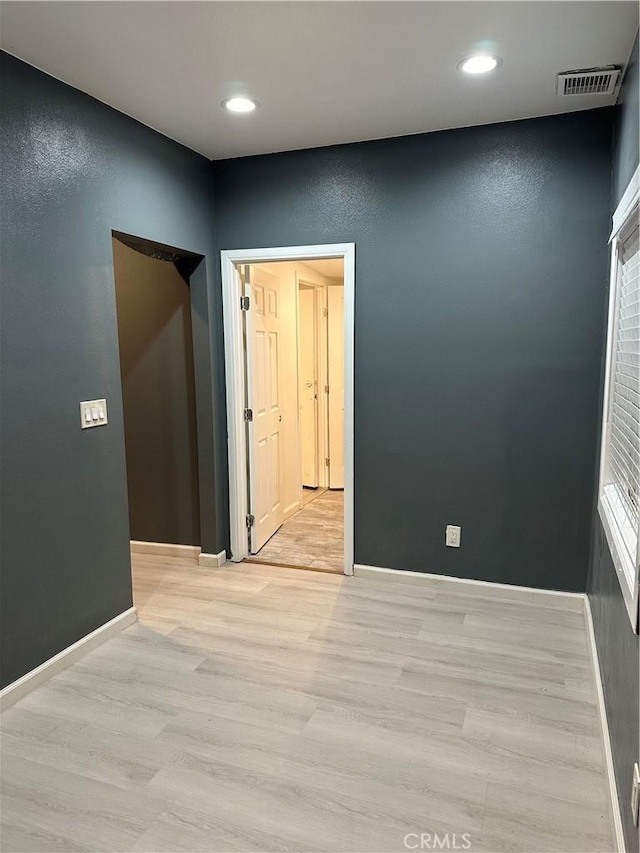 spare room featuring recessed lighting, visible vents, baseboards, and light wood-style flooring