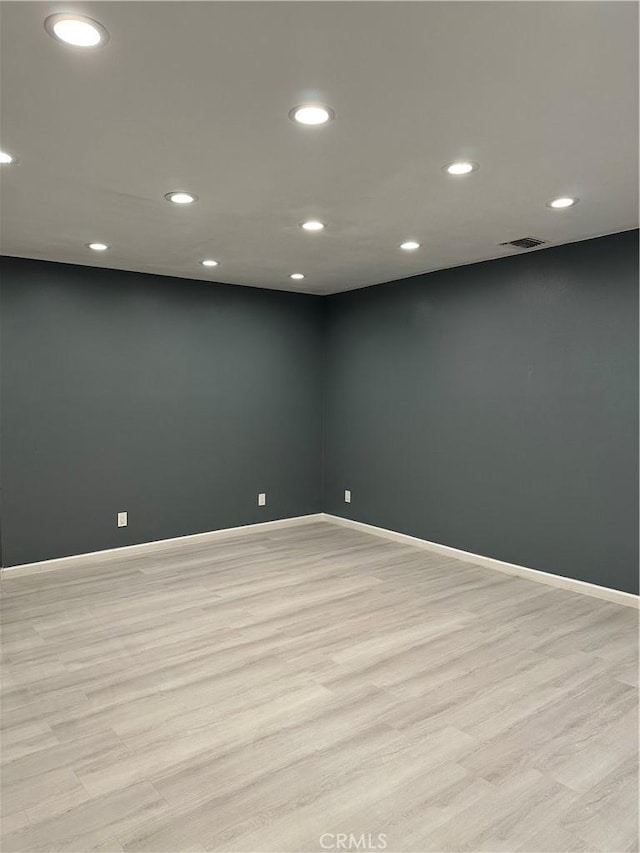 empty room with recessed lighting, visible vents, light wood-type flooring, and baseboards