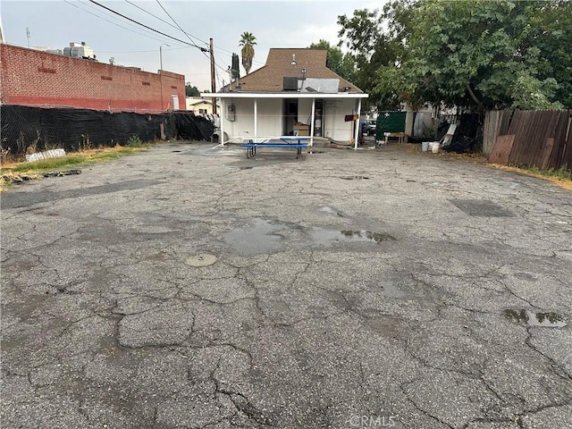 back of property featuring a trampoline and fence