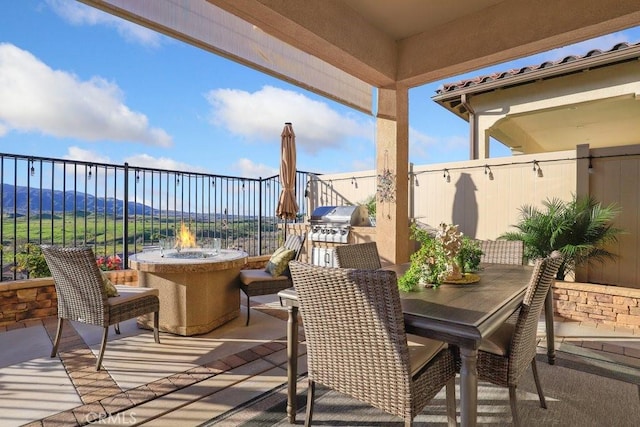 view of patio with exterior kitchen and a grill