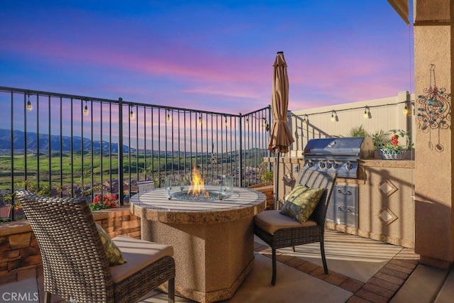 patio terrace at dusk with an outdoor kitchen and grilling area