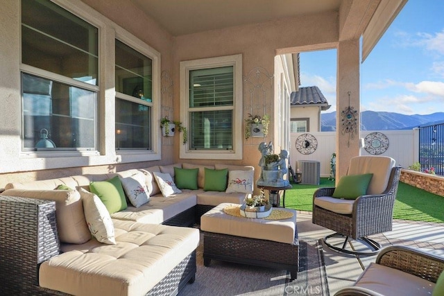 view of patio / terrace with central AC unit, an outdoor living space, and a mountain view