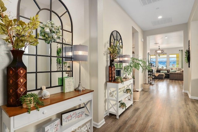 hall featuring hardwood / wood-style flooring and a notable chandelier