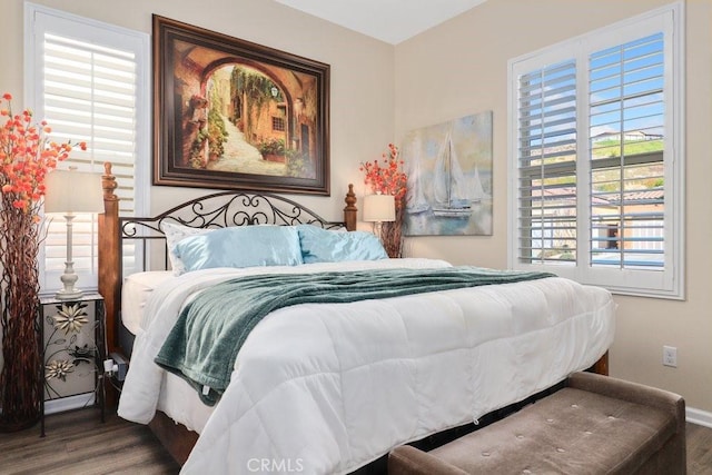 bedroom with multiple windows and wood-type flooring