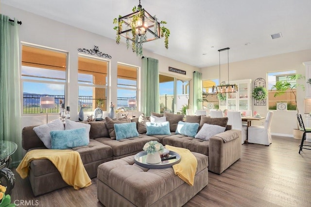 living room featuring hardwood / wood-style floors, plenty of natural light, and a notable chandelier