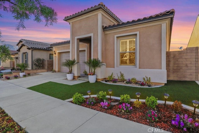 mediterranean / spanish-style home with a yard and a garage