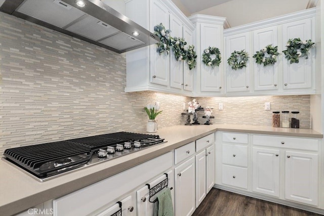 kitchen with white cabinetry, wall chimney exhaust hood, stainless steel gas cooktop, tasteful backsplash, and dark hardwood / wood-style flooring