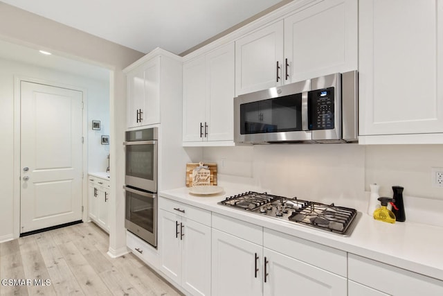 kitchen featuring white cabinetry, light wood-type flooring, and appliances with stainless steel finishes