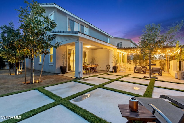 back house at dusk featuring an outdoor living space and a patio area