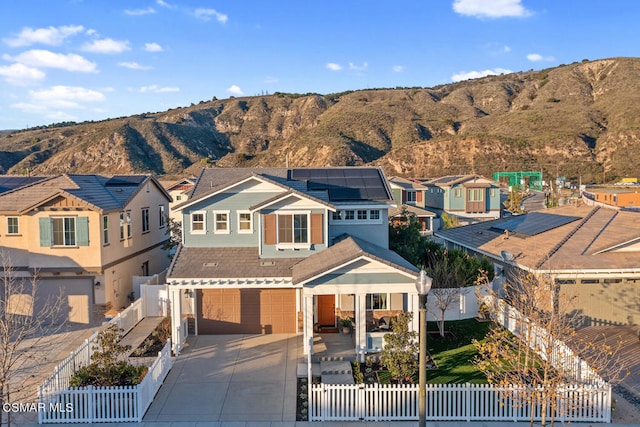 exterior space featuring a mountain view, a garage, and solar panels