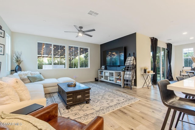 living room with light wood-type flooring and ceiling fan