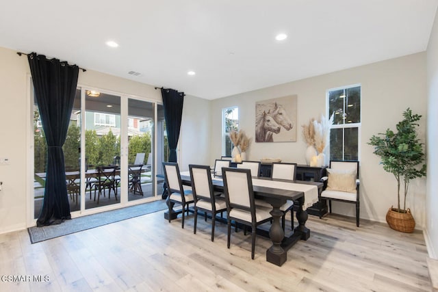 dining space with light hardwood / wood-style floors and plenty of natural light