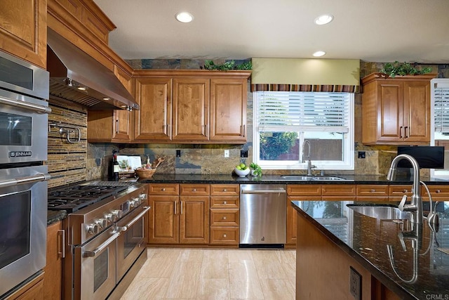 kitchen featuring decorative backsplash, stainless steel appliances, dark stone countertops, and sink