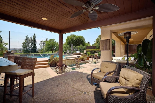 view of patio / terrace featuring pool water feature, a fenced in pool, and ceiling fan