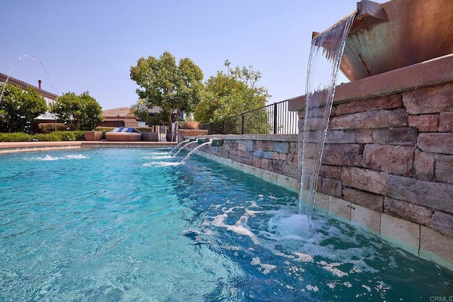 view of swimming pool with pool water feature