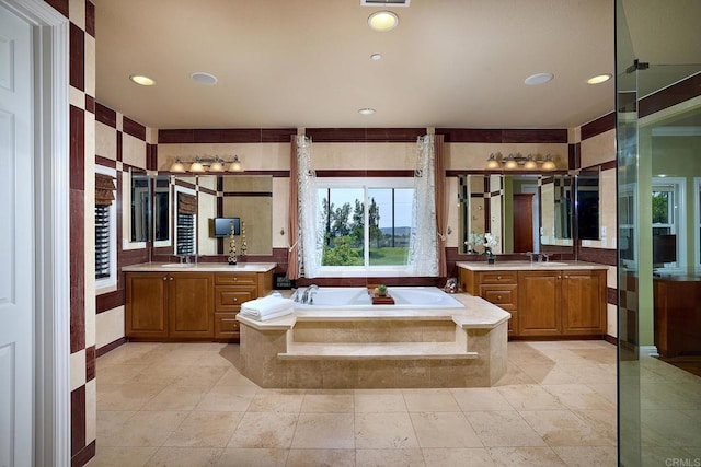 bathroom featuring tiled tub and vanity