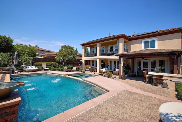 view of swimming pool with a patio, exterior bar, and pool water feature