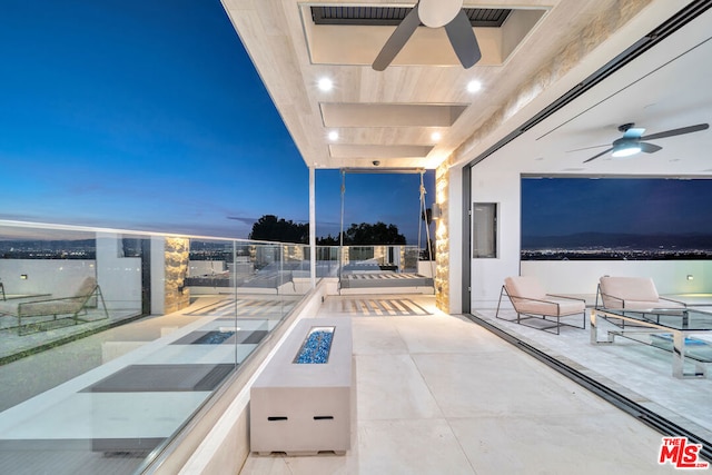 balcony at dusk featuring ceiling fan