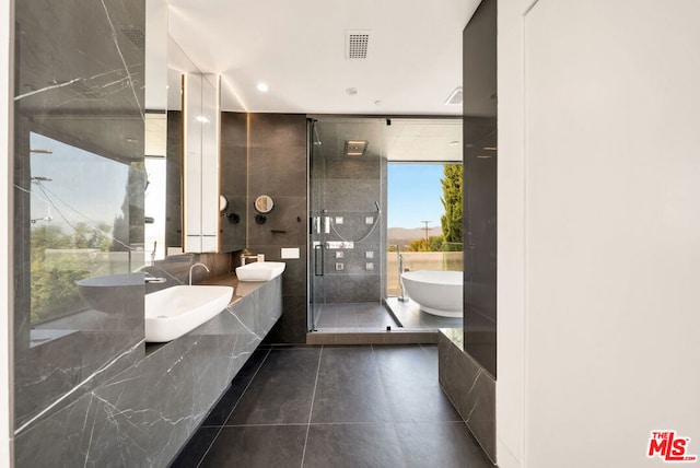 bathroom featuring double vanity, tile patterned flooring, and plus walk in shower