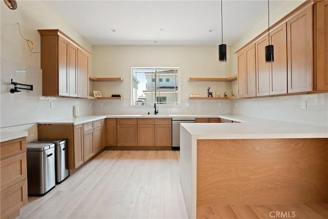 kitchen with sink, hanging light fixtures, light hardwood / wood-style flooring, stainless steel dishwasher, and kitchen peninsula