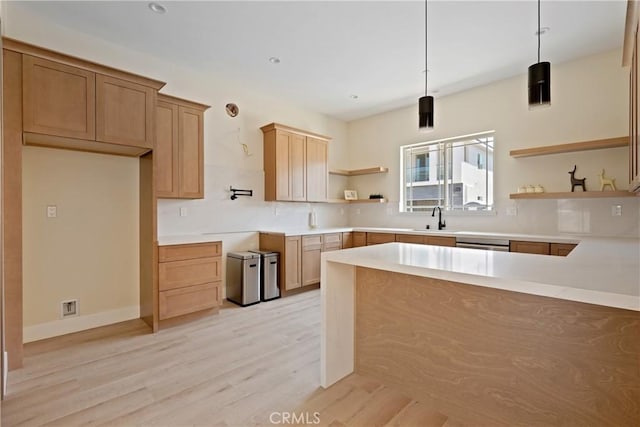 kitchen with dishwasher, light hardwood / wood-style floors, hanging light fixtures, and sink