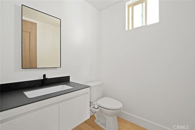 bathroom featuring vanity, hardwood / wood-style flooring, and toilet